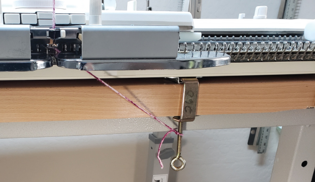 Some knitters will tie the yarn tail to the table clamp. You have to remember to remove this as you knit